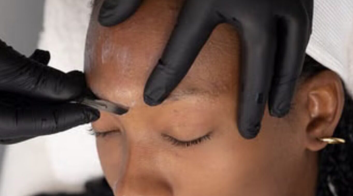 image of Michelle performing a Dermaplaning on a patient with dark skin tone